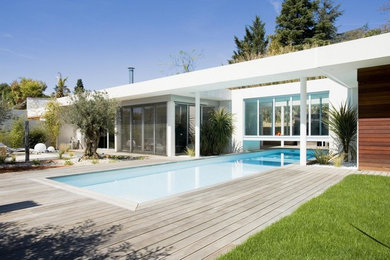 Exemple d'un couloir de nage arrière tendance rectangle avec une terrasse en bois.
