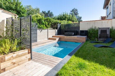 Идея дизайна: маленький прямоугольный бассейн на заднем дворе в стиле модернизм с фонтаном и настилом для на участке и в саду
