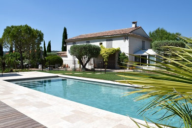 Cette photo montre une grande piscine méditerranéenne rectangle avec des pavés en pierre naturelle.
