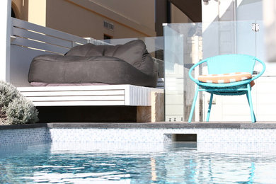 Diseño de piscina alargada contemporánea rectangular en patio delantero