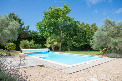 Aménagement d'une grande piscine contemporaine rectangle avec une terrasse en bois.