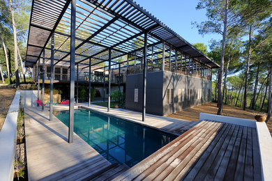 Exemple d'une piscine arrière tendance de taille moyenne et rectangle avec une terrasse en bois.