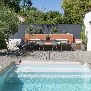Immagine di una piscina tropicale di medie dimensioni con pedane