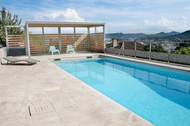 Ejemplo de piscina moderna de tamaño medio rectangular en patio trasero con suelo de baldosas