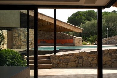 Inspiration pour un grand Abris de piscine et pool houses latéral méditerranéen sur mesure avec une terrasse en bois.
