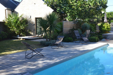 Aménagement d'une piscine latérale bord de mer de taille moyenne et rectangle avec une terrasse en bois.