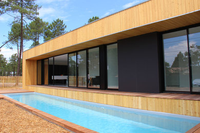 Mittelgroßes Modernes Sportbecken hinter dem Haus in rechteckiger Form mit Dielen in Bordeaux