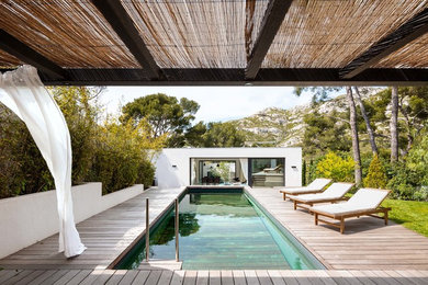 Cette photo montre un couloir de nage arrière tendance de taille moyenne et rectangle avec une terrasse en bois.
