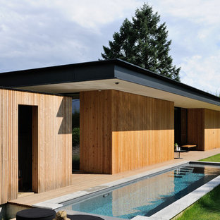 Immagine di una grande piscina monocorsia minimal rettangolare dietro casa con pedane