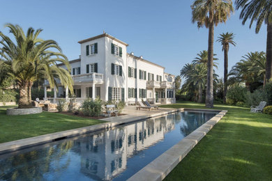 Imagen de piscina alargada mediterránea extra grande rectangular en patio trasero con suelo de baldosas