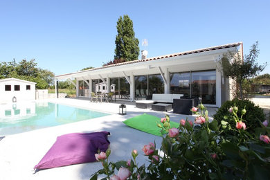 Modelo de piscina contemporánea grande rectangular en patio lateral