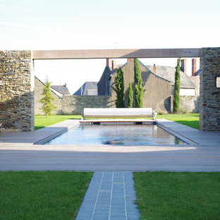 Réalisation d'une grand piscine arrière méditerranéenne rectangle.