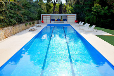 Exemple d'un grand couloir de nage tendance rectangle avec des pavés en pierre naturelle.