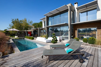 Idées déco pour un couloir de nage arrière classique rectangle avec une terrasse en bois.