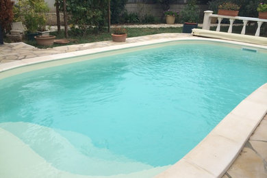 Imagen de piscina clásica renovada pequeña con adoquines de piedra natural