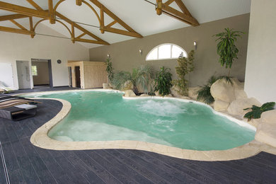 Aménagement d'une piscine intérieure naturelle bord de mer de taille moyenne et sur mesure avec du carrelage.
