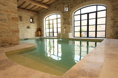 Cette image montre une petite piscine intérieure traditionnelle sur mesure avec un point d'eau et des pavés en pierre naturelle.