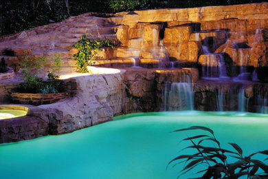 Idée de décoration pour une grande piscine naturelle tradition sur mesure avec un bain bouillonnant.
