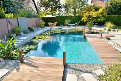 Idée de décoration pour une piscine naturelle design rectangle avec une terrasse en bois.
