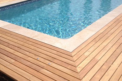 Idée de décoration pour une petite piscine hors-sol minimaliste rectangle avec une terrasse en bois.