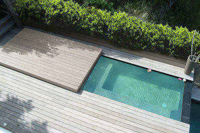 Idée de décoration pour une petite piscine à débordement design rectangle avec un bain bouillonnant, une cour et une terrasse en bois.
