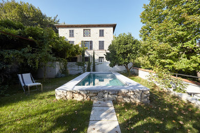 Imagen de piscina alargada minimalista de tamaño medio rectangular en patio con adoquines de piedra natural