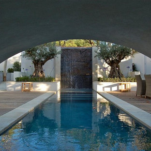 Réalisation d'une grand piscine arrière design rectangle avec un point d'eau.