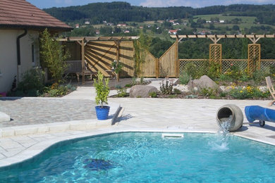 Cette photo montre une grande piscine arrière chic sur mesure avec des pavés en béton.