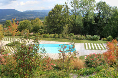 Inspiration pour une piscine design sur mesure avec une terrasse en bois.