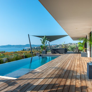 Immagine di una piscina a sfioro infinito minimal rettangolare con pedane