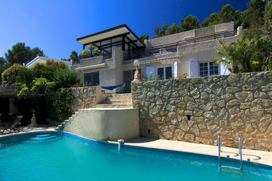 Photo of a large rural custom shaped infinity swimming pool in Marseille with natural stone paving.