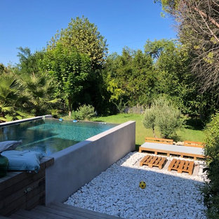 Ispirazione per una grande piscina monocorsia design rettangolare dietro casa con pedane