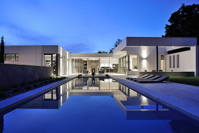 Large contemporary back rectangular swimming pool in Lyon with decking.