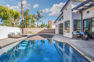 Mid-sized trendy backyard custom-shaped pool photo in Orange County