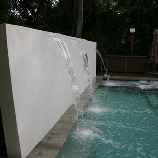 Foto di una grande piscina minimalista rettangolare dietro casa con fontane e pedane