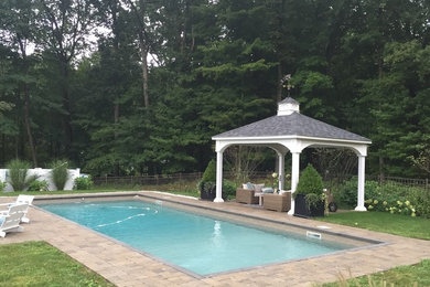 Pool - large traditional backyard rectangular pool idea in New York