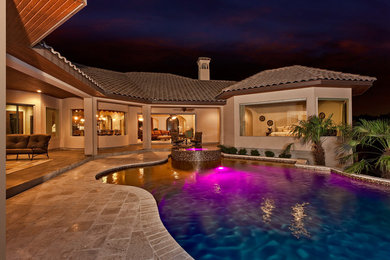 Inspiration for a large mediterranean backyard stone and custom-shaped hot tub remodel in Austin