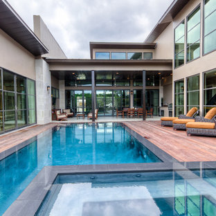 Ispirazione per una piscina a sfioro infinito contemporanea rettangolare in cortile con pedane e una vasca idromassaggio