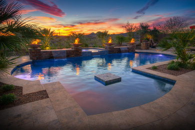 Diseño de piscina con fuente actual grande a medida en patio trasero con adoquines de piedra natural