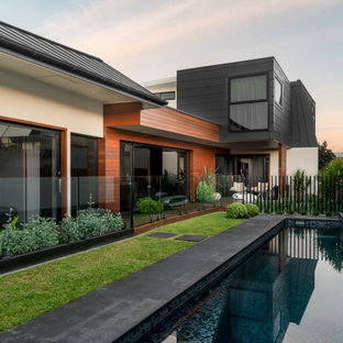 This is an example of a large contemporary backyard rectangular lap pool in Sydney with concrete slab.