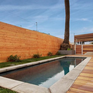 Immagine di una piscina monocorsia moderna rettangolare di medie dimensioni e dietro casa con pedane