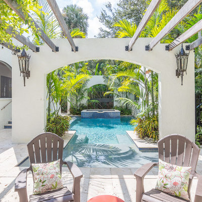 Example of an island style backyard custom-shaped pool fountain design in Orlando
