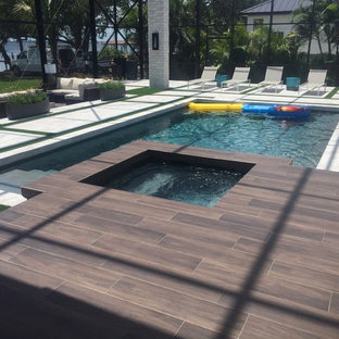 Foto di un'ampia piscina naturale minimalista personalizzata dietro casa con pedane