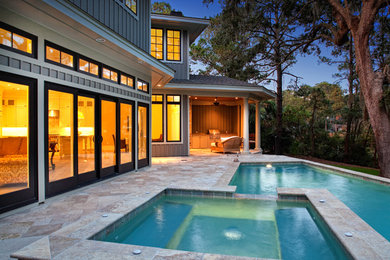 Immagine di una piscina tradizionale personalizzata di medie dimensioni e dietro casa con una vasca idromassaggio e pavimentazioni in pietra naturale