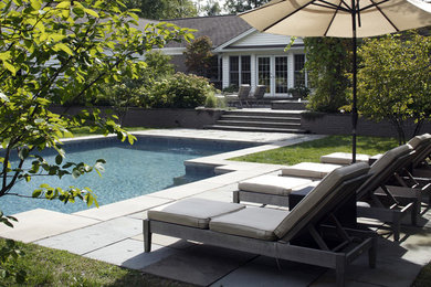 Example of a mid-sized transitional backyard pool design in New York