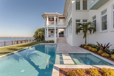 Ejemplo de piscinas y jacuzzis mediterráneos grandes rectangulares en patio trasero con suelo de baldosas