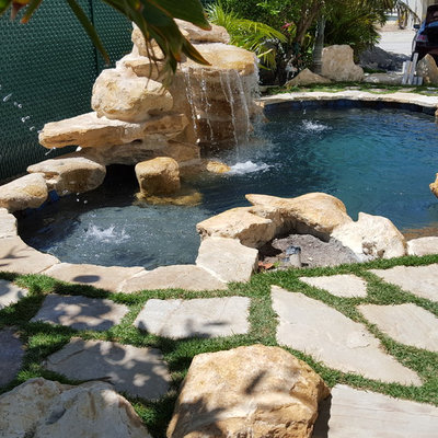 Inspiration for a small tropical backyard stone and custom-shaped natural pool fountain remodel in Miami