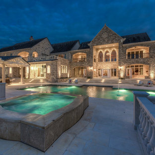 Design ideas for a large victorian backyard rectangular pool in Austin with a hot tub and natural stone pavers.