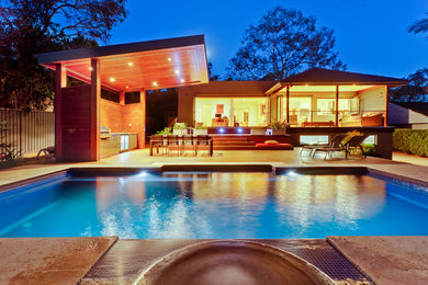 Пример оригинального дизайна: прямоугольный бассейн среднего размера на заднем дворе в стиле модернизм с домиком у бассейна и покрытием из каменной брусчатки
