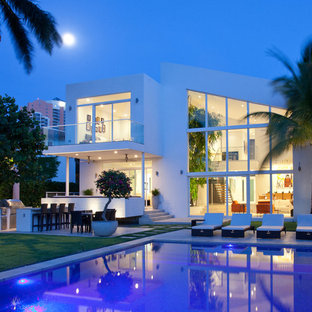 Inspiration for a large contemporary backyard rectangular lap pool in Miami with concrete pavers.